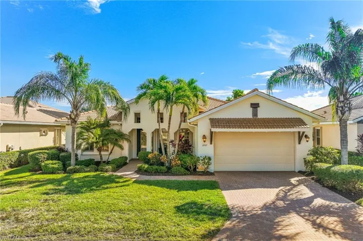 View of front of house featuring stucco siding, decorative driveway, a tiled roof, a garage, and a front lawn