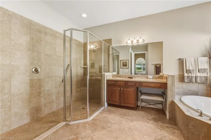 Full bathroom featuring vanity, a stall shower, a garden tub, recessed lighting, and light tile patterned flooring