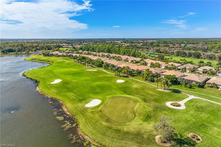 Aerial view of residential area with a nearby body of water and a golf course