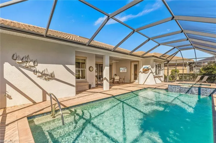 View of swimming pool featuring a sunroom, a lanai, a ceiling fan, a pool with connected hot tub, and a patio area