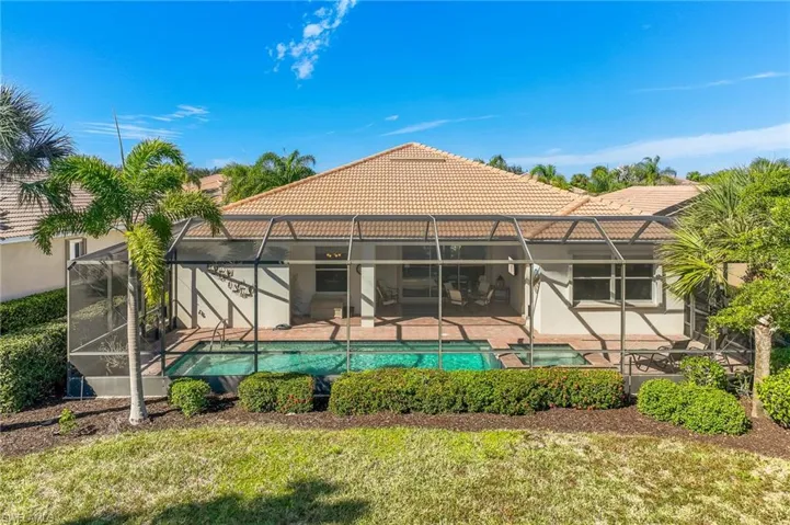 Back of house featuring a sunroom, a tiled roof, and glass enclosure