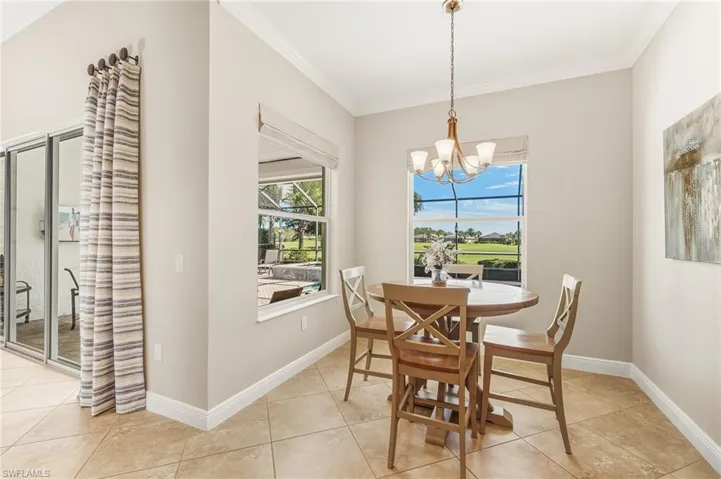 Dining space featuring plenty of natural light, light tile patterned flooring, ornamental molding, and a chandelier