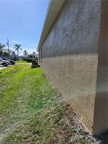 View of property exterior with cooling unit and a yard