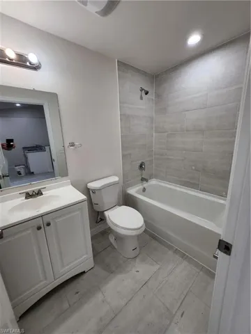 Full bathroom featuring toilet, tiled shower / bath, and vanity
