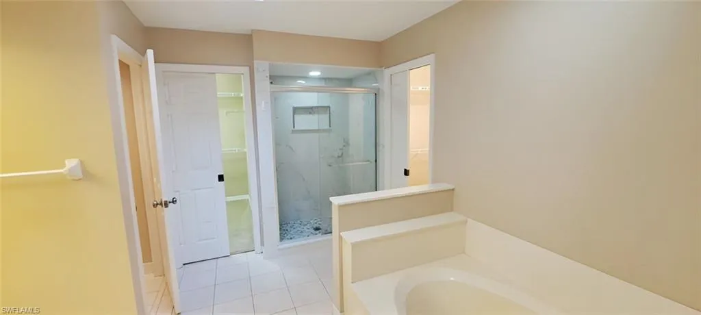 Bathroom with tile patterned flooring and separate shower and tub