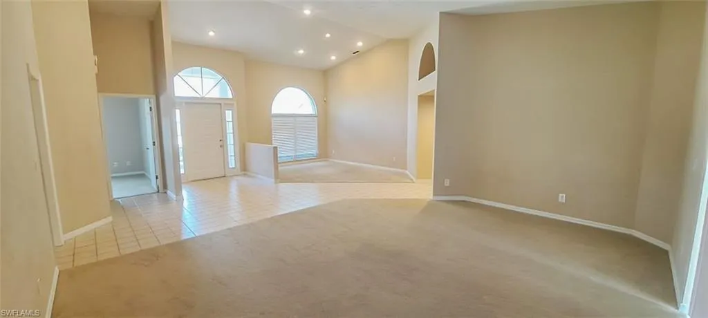 Entryway featuring a towering ceiling and light colored carpet