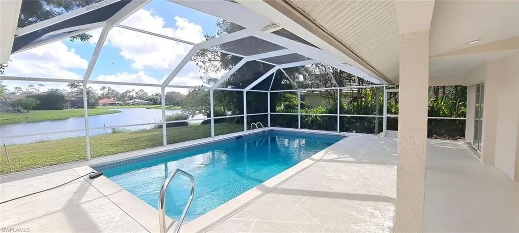 View of pool featuring a patio, a water view, a lanai, and a yard