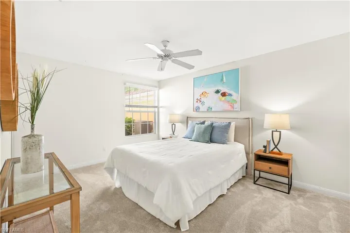 Bedroom featuring baseboards, ceiling fan, and light carpet