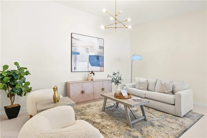 Living area with baseboards, an inviting chandelier, and tile patterned flooring