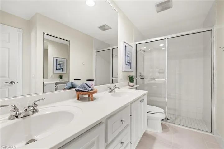 Full bathroom featuring a stall shower, tile patterned floors, and a sink