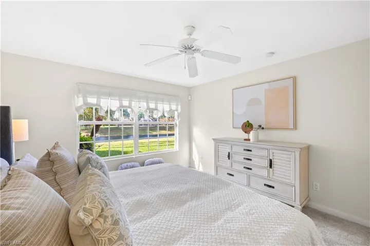 Bedroom featuring light carpet, baseboards, and ceiling fan