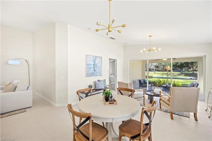 Dining space featuring lofted ceiling, an inviting chandelier, baseboards, light tile patterned flooring, and visible vents