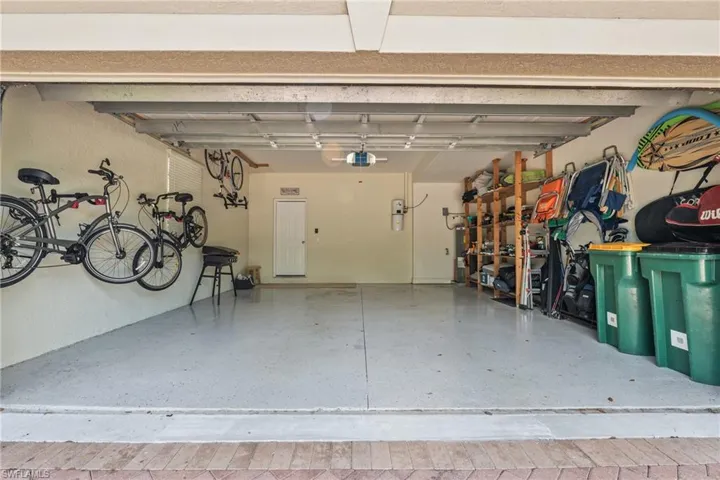 Attached garage featuring an epoxy-coated floor, overhead lighting, and interior access door
