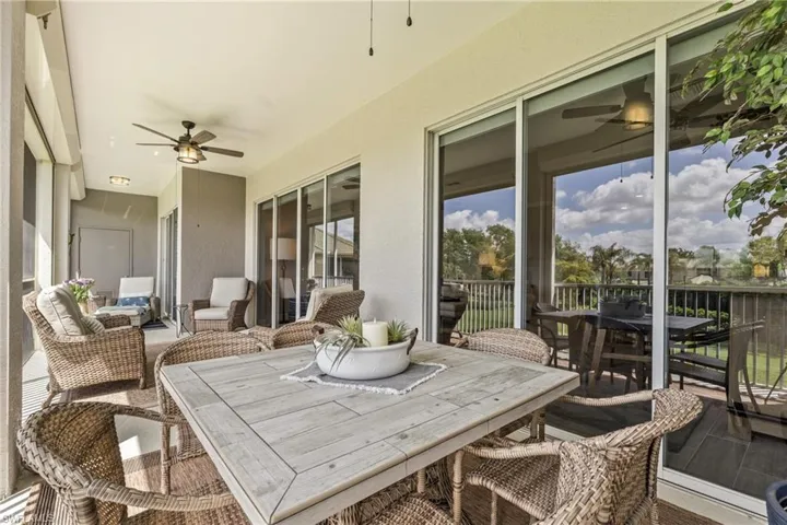Screened outdoor living area with dual ceiling fans, recessed lighting, and multiple sliding glass doors