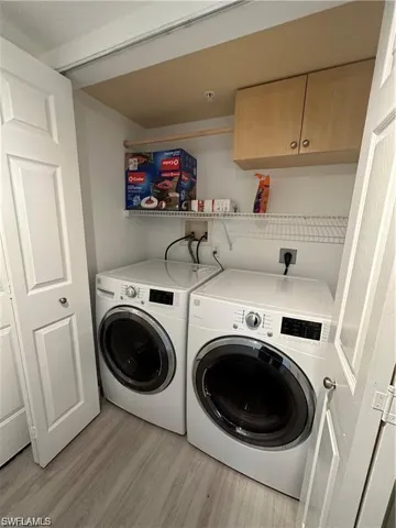 Laundry room featuring light wood-style flooring and washer and clothes dryer