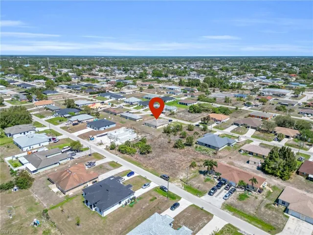 Aerial view of property and surrounding area featuring nearby suburban area