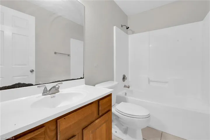 Bathroom with vanity, shower / washtub combination, and light tile patterned floors