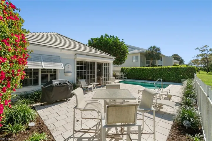 View of patio with a fenced in pool and grilling area