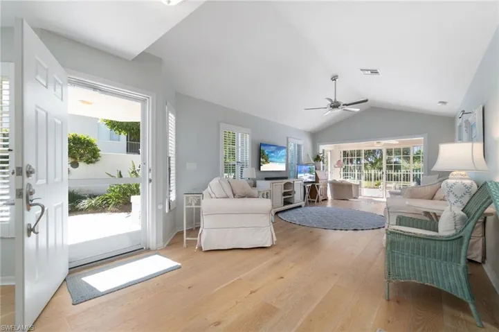 Living room featuring ceiling fan, light hardwood / wood-style floors, and vaulted ceiling