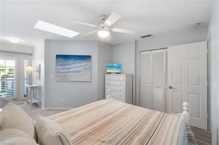 Bedroom featuring light carpet, a closet, and ceiling fan
