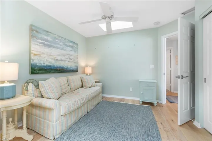 Living room with ceiling fan and light wood-type flooring