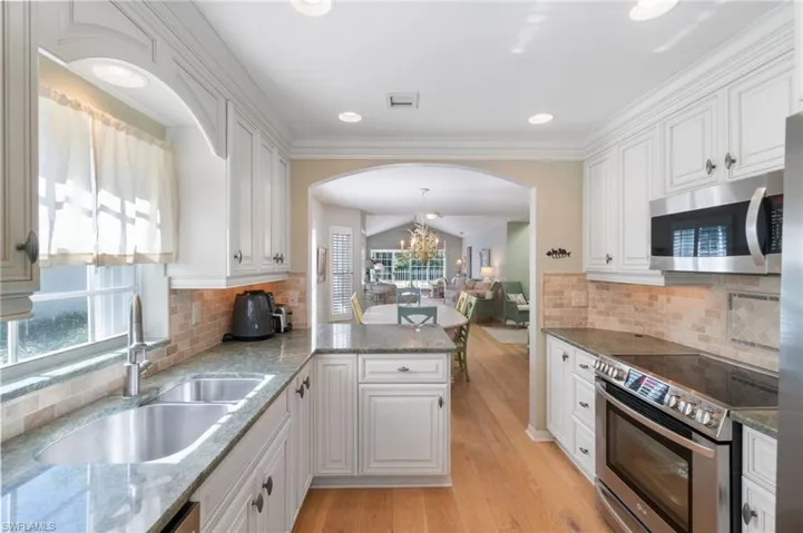 Kitchen featuring white cabinets, stainless steel appliances, and plenty of natural light
