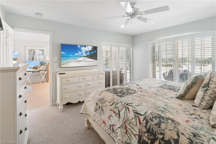 Carpeted bedroom featuring ceiling fan