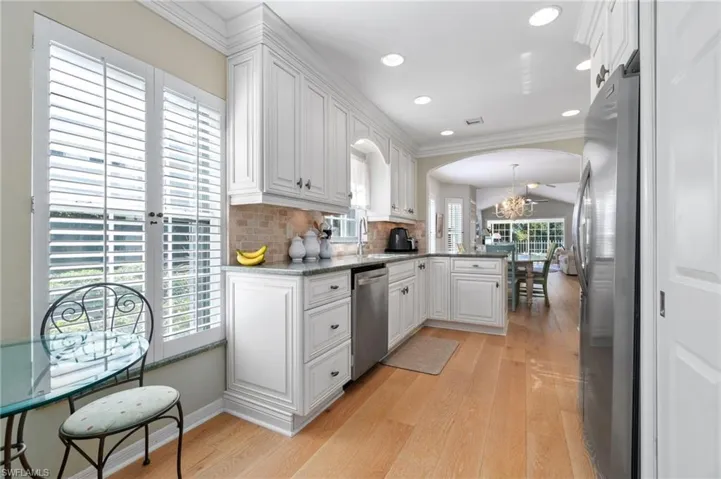 Kitchen with kitchen peninsula, plenty of natural light, white cabinets, and stainless steel appliances