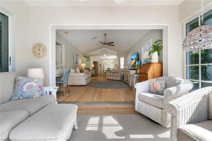 Living room featuring ceiling fan, light hardwood / wood-style flooring, and vaulted ceiling