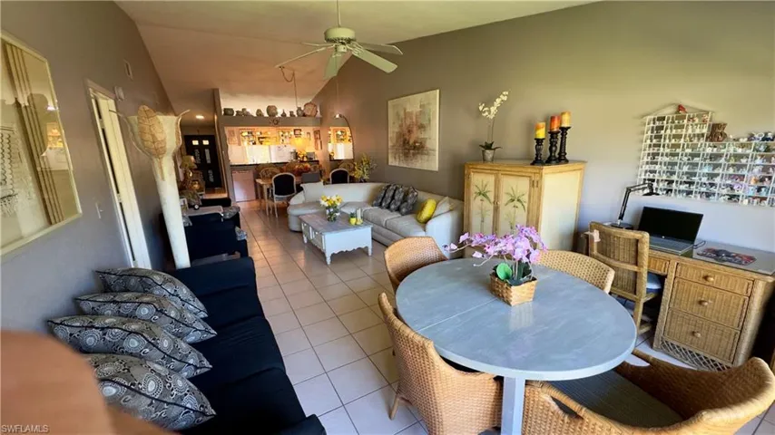 Dining room with vaulted ceiling, tile flooring, and a ceiling fan and large window with beautiful view