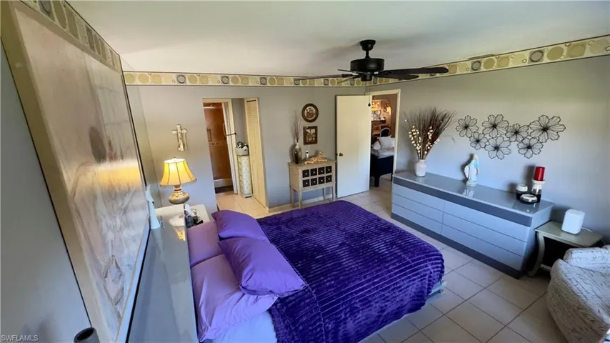 Primary Bedroom featuring light tile  flooring, ceiling fan, and ensuite bath