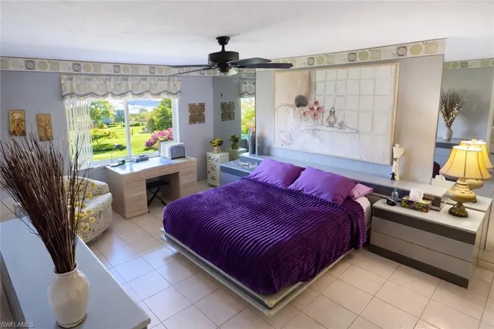 Bedroom featuring light tile patterned floors, a ceiling fan, and an office area
