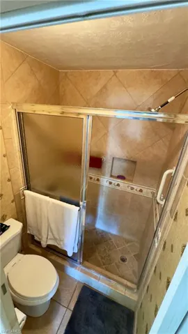 Primary Full bathroom with a shower stall and tile patterned flooring