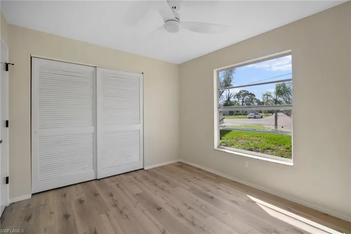 Unfurnished bedroom featuring multiple windows, light hardwood / wood-style flooring, and a closet