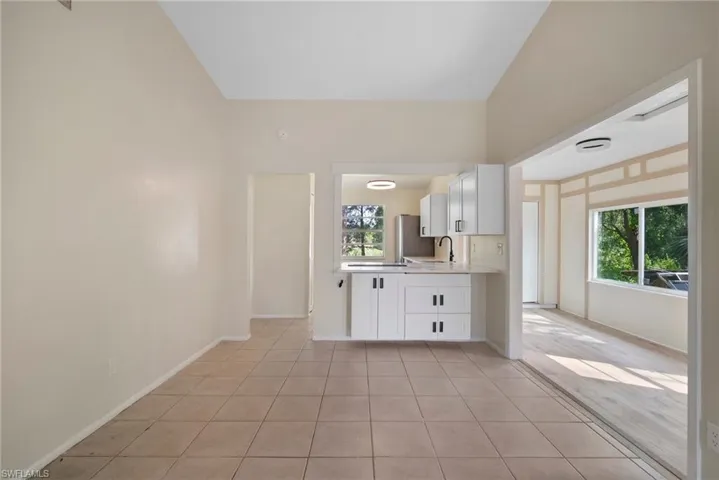 Kitchen with white cabinetry, a healthy amount of sunlight, light tile patterned floors, and sink