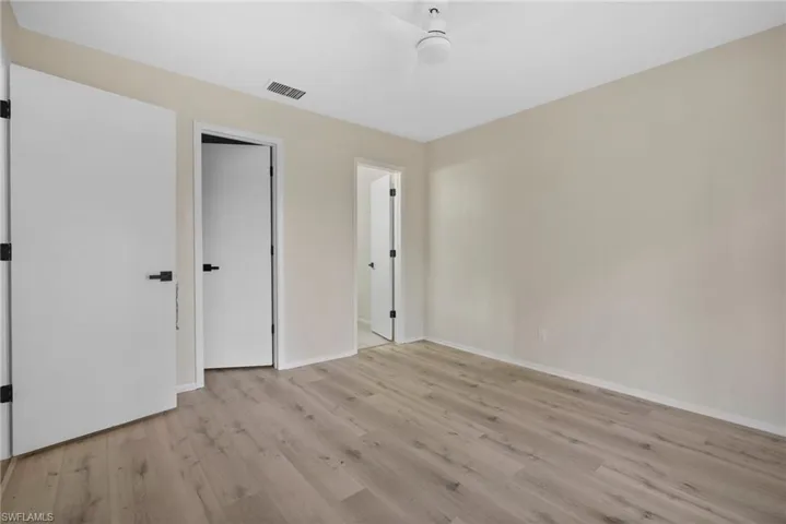 Unfurnished bedroom with ceiling fan and light hardwood / wood-style floors