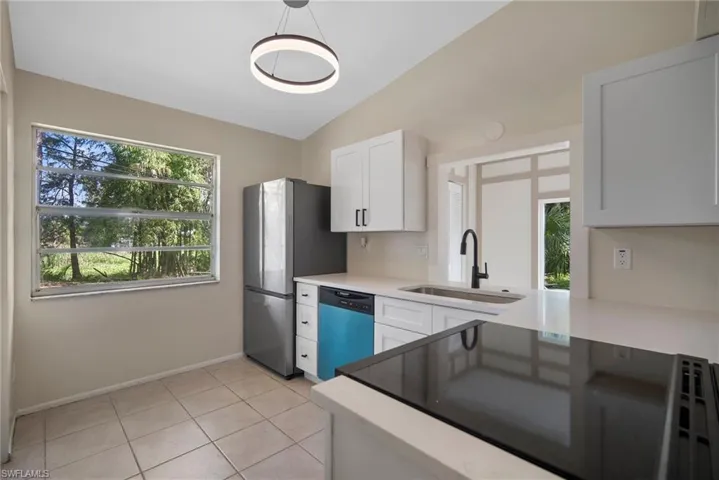 Kitchen with plenty of natural light, sink, appliances with stainless steel finishes, and white cabinets