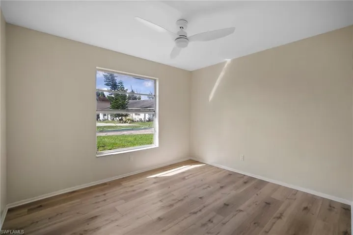 Empty room with ceiling fan and hardwood / wood-style flooring