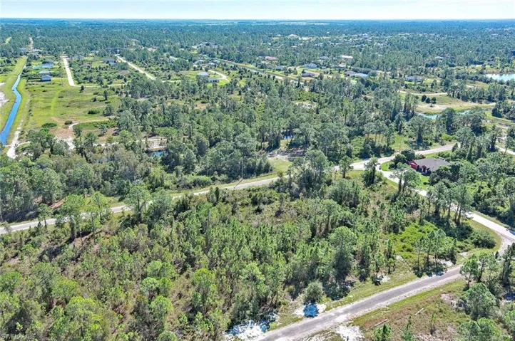 Aerial view of property and surrounding area featuring a heavily wooded area