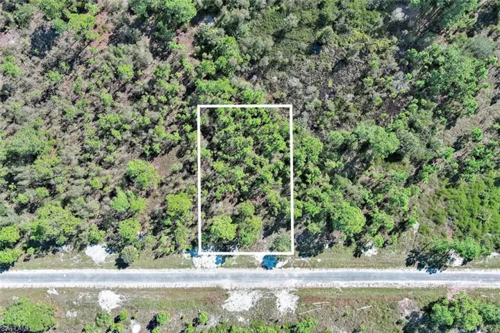 Aerial view of property and surrounding area featuring property boundaries highlighted