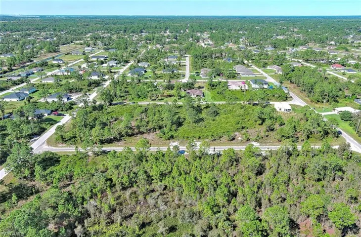 Aerial overview of property's location with a heavily wooded area