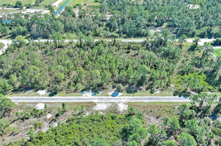 Aerial view of property's location featuring a heavily wooded area