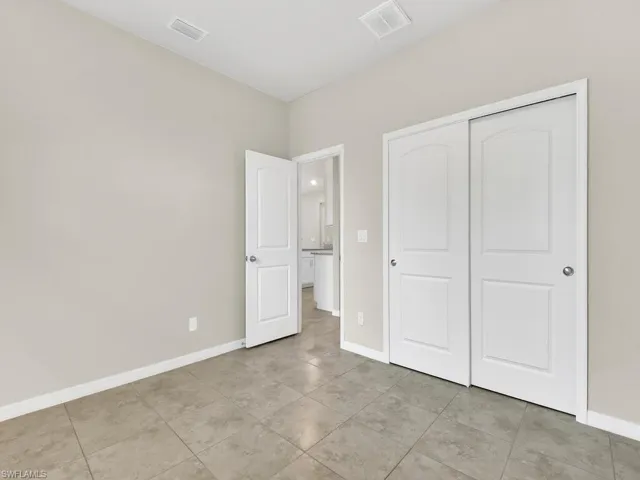 Unfurnished bedroom with a closet and light tile patterned floors