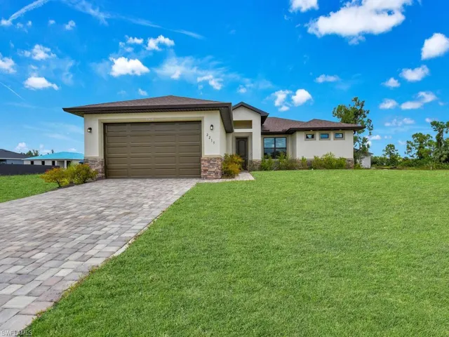 View of front of home featuring a front lawn and a garage