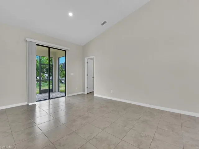 Spare room with high vaulted ceiling and light tile patterned flooring