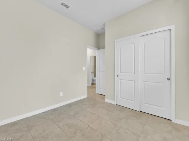 Unfurnished bedroom with light tile patterned floors and a closet