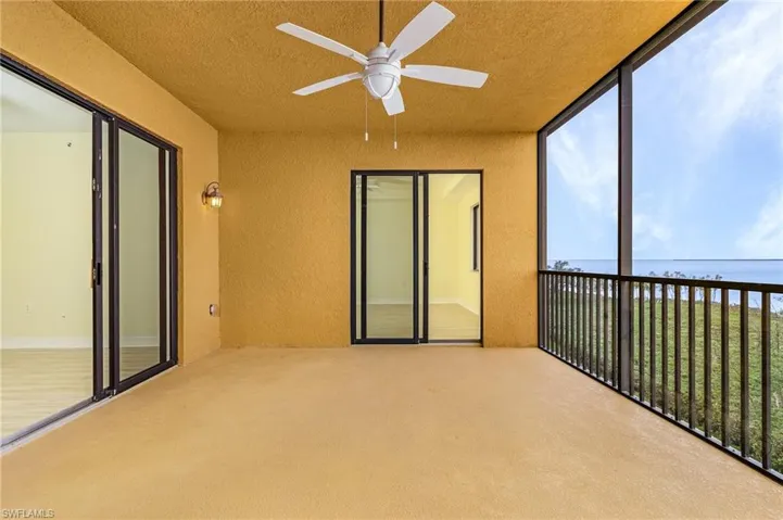 Unfurnished sunroom featuring a water view and ceiling fan