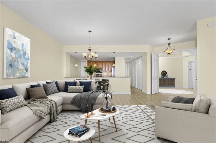 Living room featuring baseboards, a chandelier, and light wood finished floors