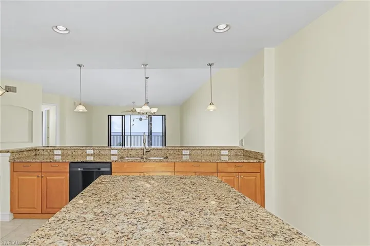 Kitchen featuring recessed lighting, brown cabinetry, a sink, and light tile patterned floors