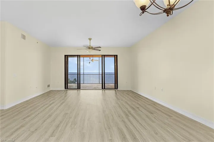 Empty room with light wood-type flooring, baseboards, and visible vents